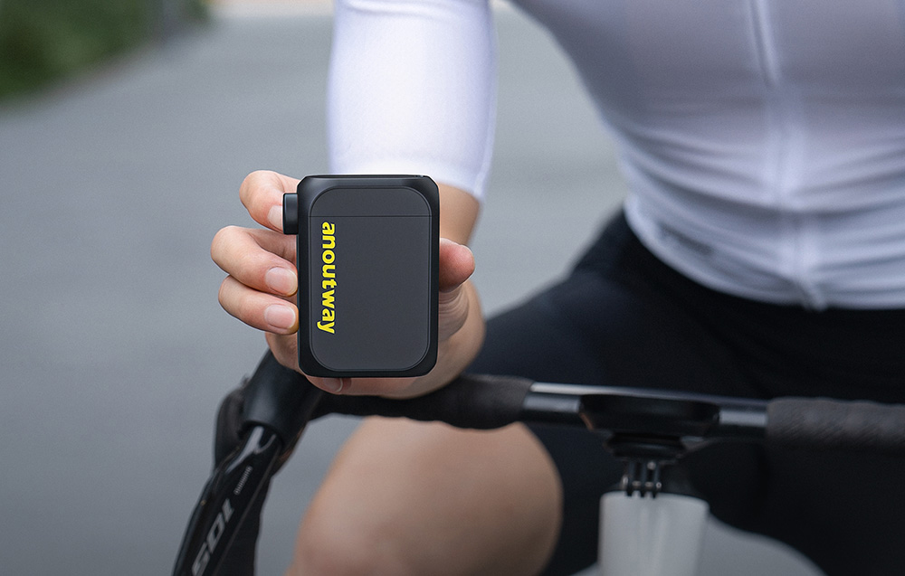 Kompaktowa, czarna pompka rowerowa Cycplus AS210 MAX AT1 Max trzymana w dłoni przez rowerzystę podczas jazdy.